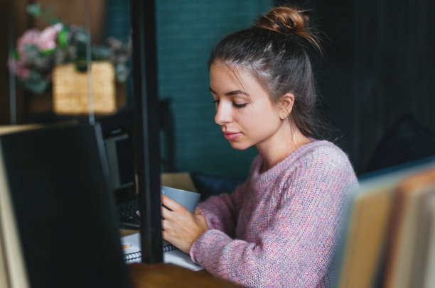 年轻女子使用笔记本电脑在家工作图片下载