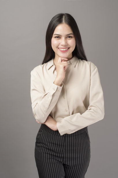 肖像美丽的商业女人微笑在灰色的背景图片下载