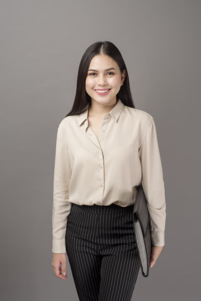 肖像美丽的商业女人微笑在灰色的背景图片下载