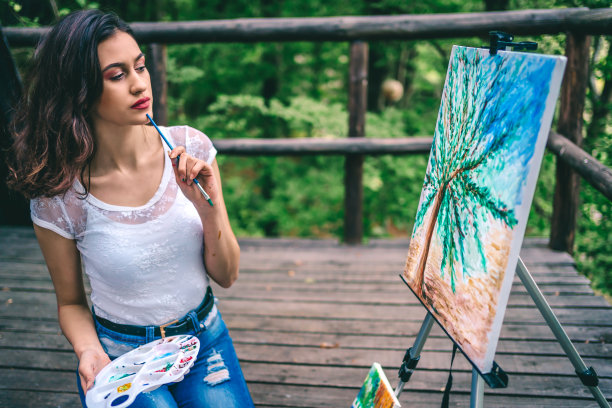 有创意的年轻女子在户外作画图片下载