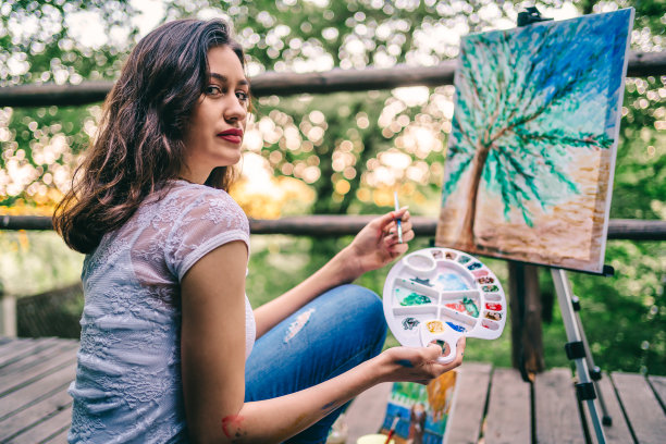 年轻女子正在画一幅画图片下载