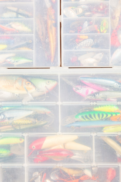 不同的钓具与鱼饵和卷轴在木制的棕色背景与文字的地方。广告及出版设计。图片下载