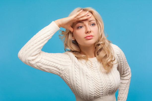 好奇迷人的女人，一头金色卷发，手举着头望着远方，寻找着地平线，发现着新的东西图片下载