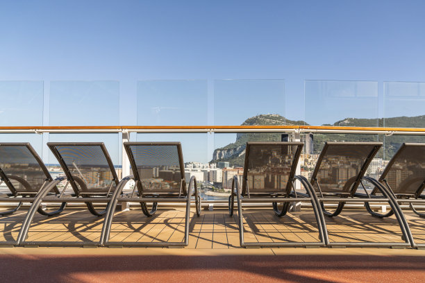 一排空的日光浴长椅上的游轮木制甲板日落时刻图片下载