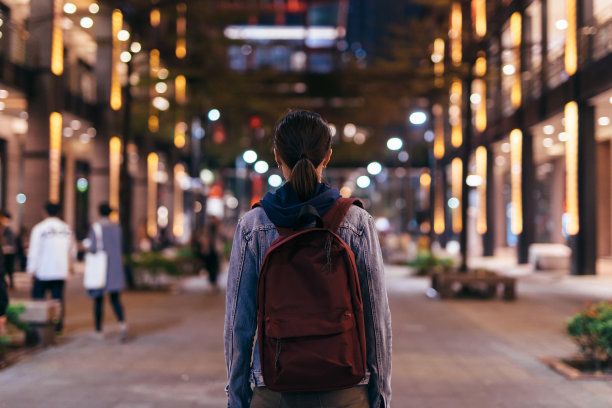 女人走过夜城。从后面看。图片下载