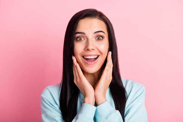 迷人的学生女士的照片听好消息张开嘴手臂在颧骨上穿运动衫孤立的粉红色背景图片下载