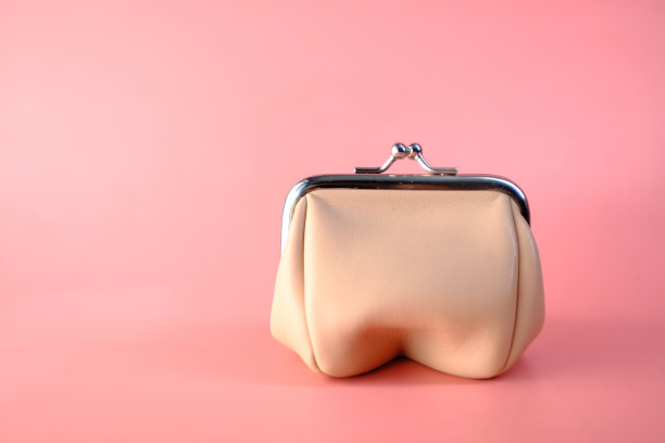 小女人的皮夹上有粉红色的背景，特写。图片下载
