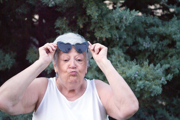 年长的女人看着镜头做了一个接吻的手势。图片下载