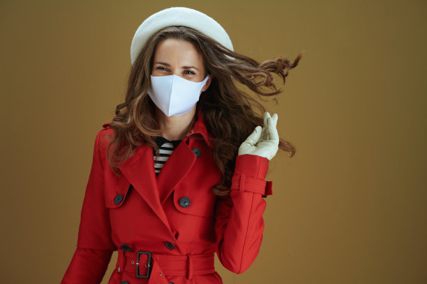 快乐的现代女人在米色的背景大衣图片下载