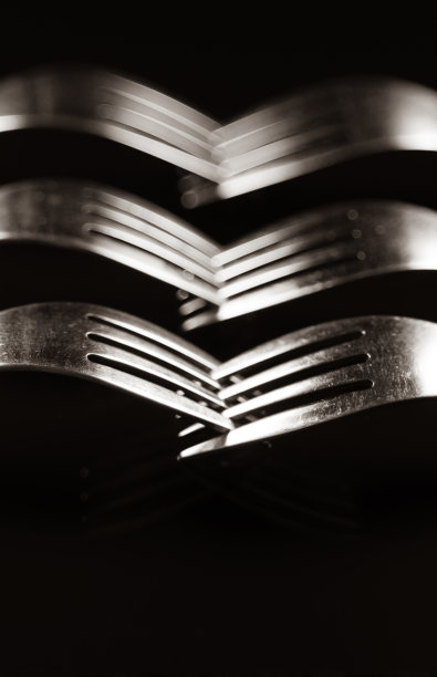 在黑色背景上用叉子做成的构图。图片下载