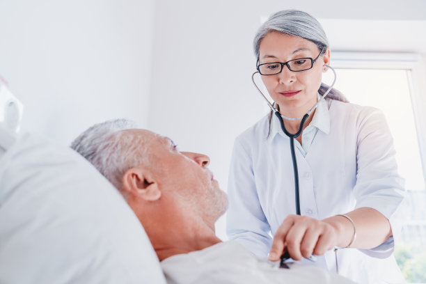 住院男子在医疗诊所接受女医师检查素材图片