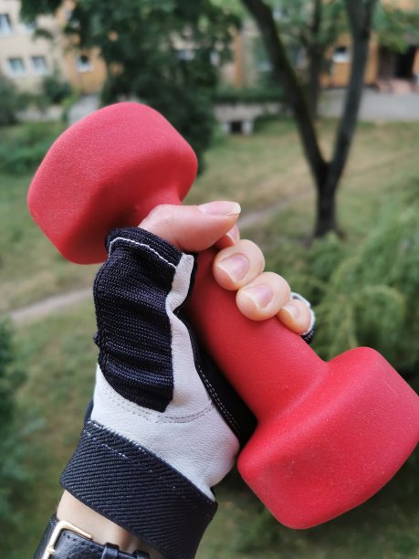 女人的手拿着一个红色的哑铃。图片下载