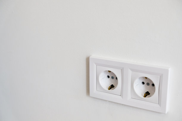 白色墙壁上有两个白色欧洲220W高压插座，空白拷贝空间。图片下载