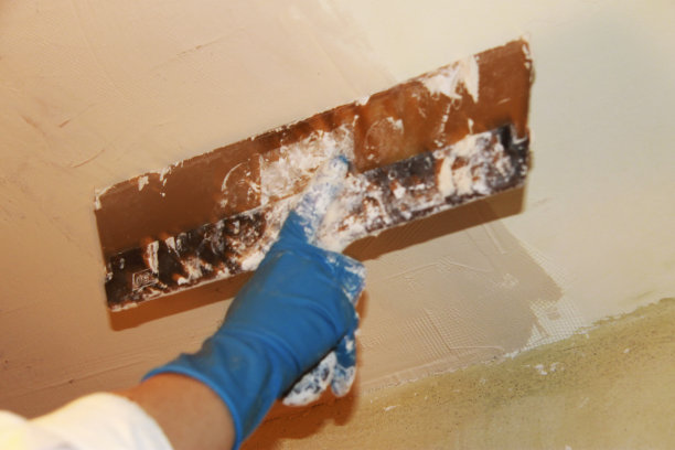 一位女灰泥油漆工正在修补室内天花板图片下载