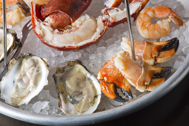 海鲜塔。牡蛎，虾，龙虾，蟹腿，鱼子酱。新鲜的牡蛎配上葱和鸡尾酒酱汁，木犀草酱汁和新鲜的柠檬和酸橙。经典的美国牛排或法式小酒馆开胃菜。图片下载