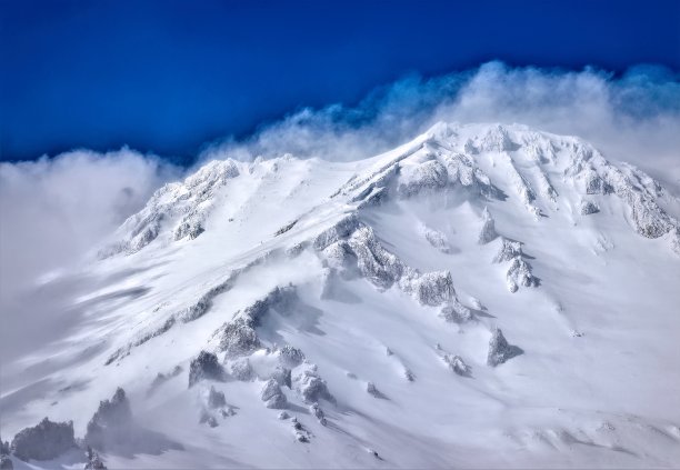 乌云笼罩着白雪覆盖的火山图片下载