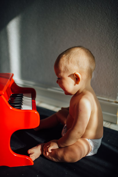 有创意的宝宝一边学习音乐一边弹奏玩具钢琴图片下载