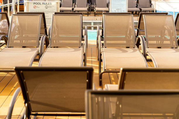 一排空的日光浴长椅上的游轮木制甲板日落时刻图片下载