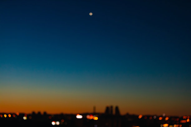 模糊的城市在黎明与星星的天空照片。图片下载