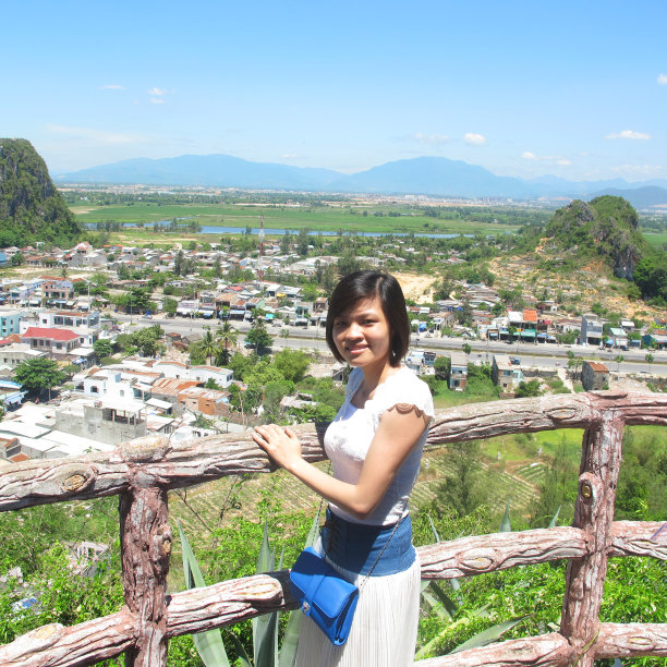 美丽的女人站在山顶，下面是美丽的景色图片下载