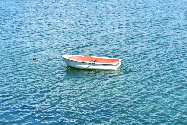 白色和红色的木制划艇漂浮在海上。Rias Baixas，加利西亚，西班牙。图片下载
