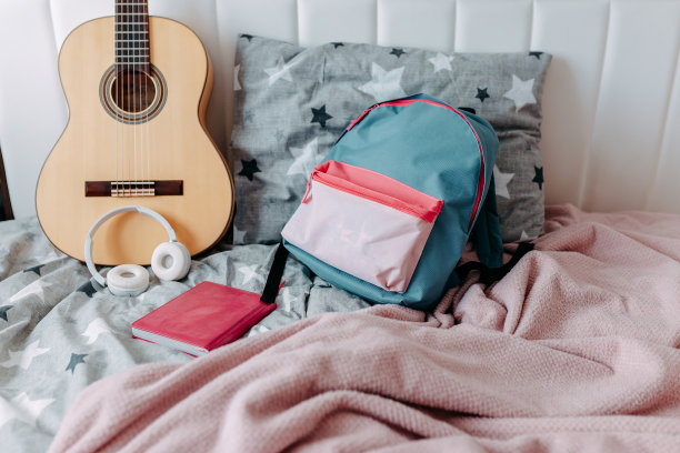 学习后的学生房间。床上放着吉他、背包、耳机和笔记本。图片下载