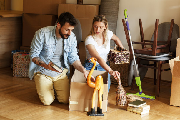 一对已婚夫妇在新家打开纸板箱。图片下载