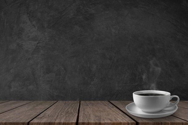 木桌上放着热咖啡，深色的灰泥墙作为背景。本空间素材图片
