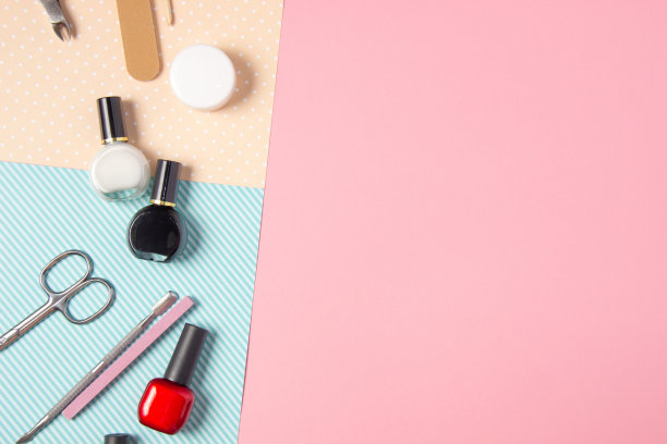 粉色和蓝色背景的美甲工具。指甲锉，剪刀和指甲油俯视图。指甲沙龙，美容沙龙图片下载