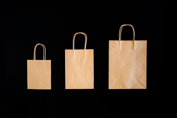 黑色星期五促销打折概念。工艺纸袋与字销售在黑色背景图片下载