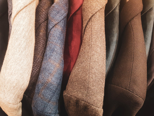 设置，许多优雅的西装衣架俯视图。衣柜里面有许多智能套装排成一排，从上面看，衣服的背景、质地。选择一个组织图片下载