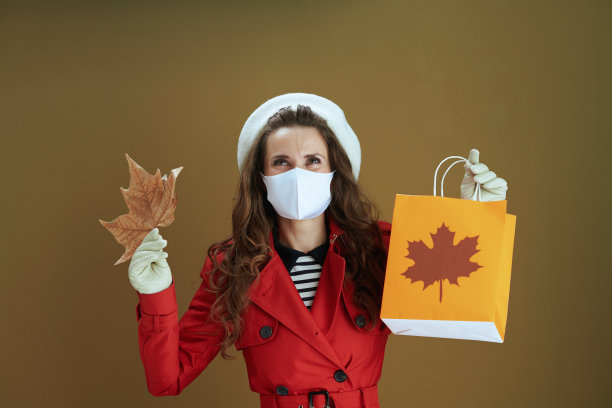 穿着红色外套的年轻家庭主妇被孤立在青铜背景上图片下载