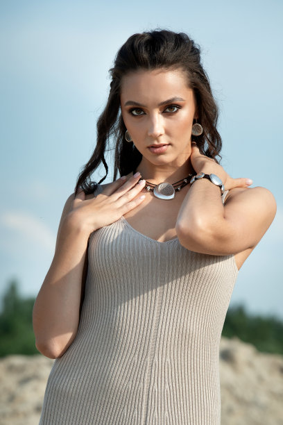 时尚女孩肖像，照片中的美丽的波西米亚模特在米色连衣裙和银色的波西米亚珠宝在海滩上日落图片下载