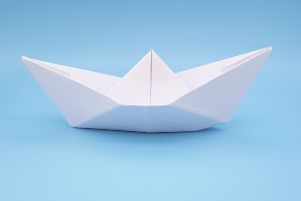 纸船折纸在蓝色背景表面如水图片下载