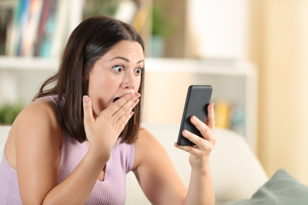 惊讶的女人检查手机发现惊人的内容图片下载