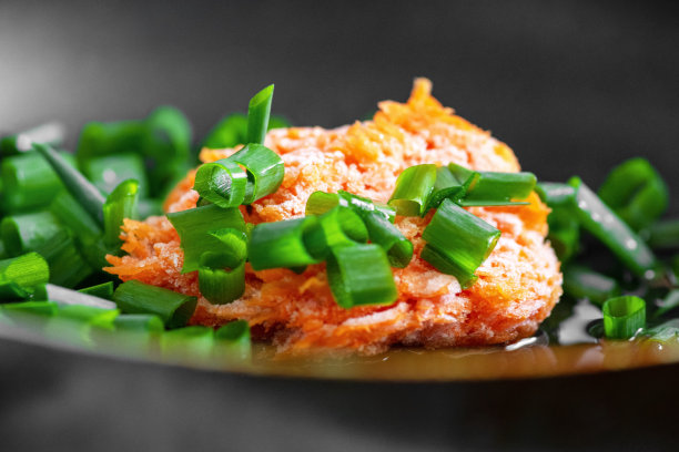 黑色平底锅里的冷冻胡萝卜和大葱。烤肉炉图片下载