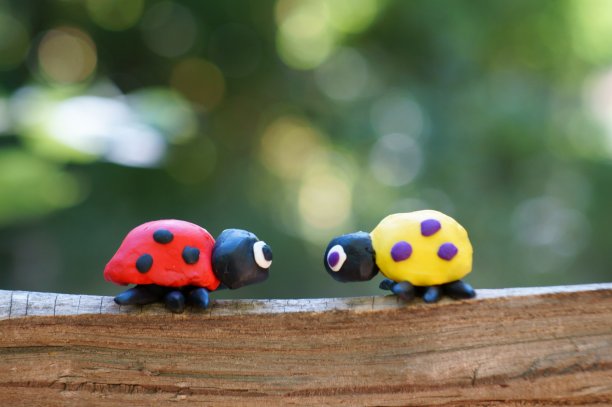 两个橡皮泥做的瓢虫在彩色的背景。图片下载