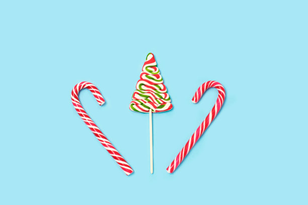 绿色糖果圣诞树和糖果罐在浅蓝色的背景。图片下载