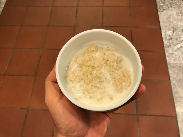 手里拿着碗里的牛奶的小麦。图片下载