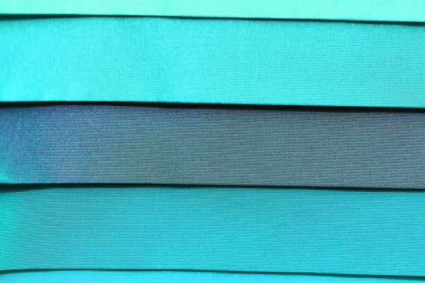 在面料市场上发现的不同颜色的布料和织物样品的详细近距离查看图片下载