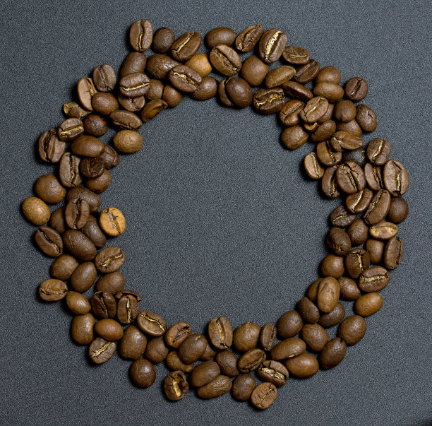 咖啡豆在灰色的背景上排成一个圆圈图片下载