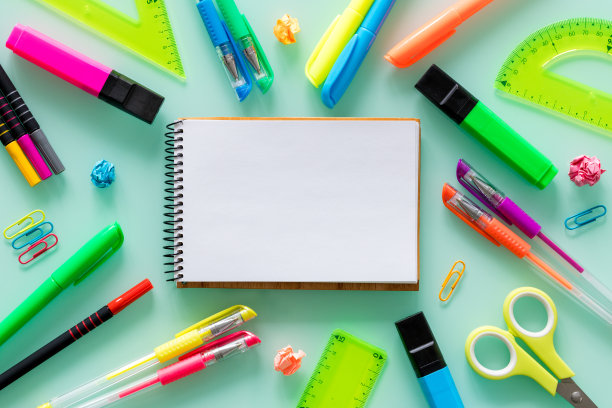 学校和办公用品，彩色笔，订书钉，毡尖笔，方形，一个空白的笔记本，为自己的文本在中间。图片下载