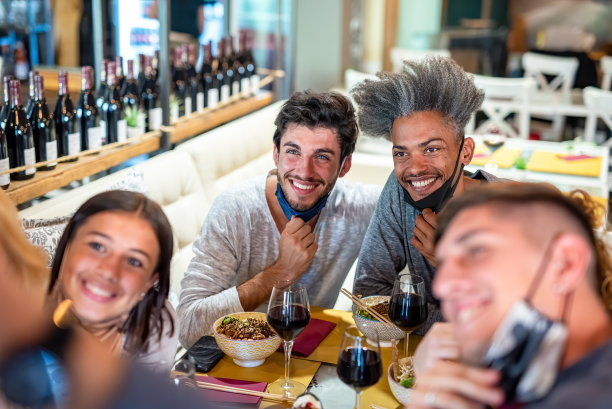 不同种族的朋友们在这家日本餐厅摆姿势自拍，以那名黑人为焦点，庆祝戒严令结束，并使用口罩预防疾病图片下载