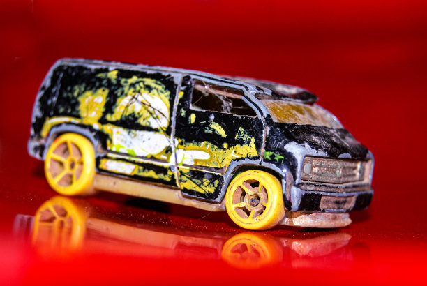 黑色和黄色的迷你货车玩具与红色的背景图片下载