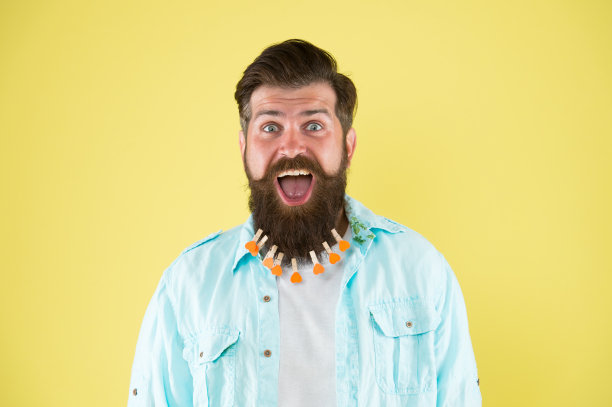 自信,英俊。男人把衣服夹在胡子上。野蛮的男人把有心形的衣服夹在胡子上。胡子男人休闲风格。衣服洗后。在理发店吹头发。理发师的概念图片下载