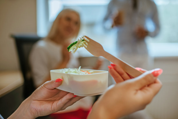 女商人在办公室吃蔬菜沙拉图片下载