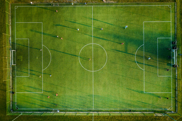 无人机俯视图照片的足球场，看到在一个小的地中海村庄。图片下载
