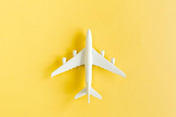 白色模型飞机，黄色背景上的飞机。俯视图，平放图片下载