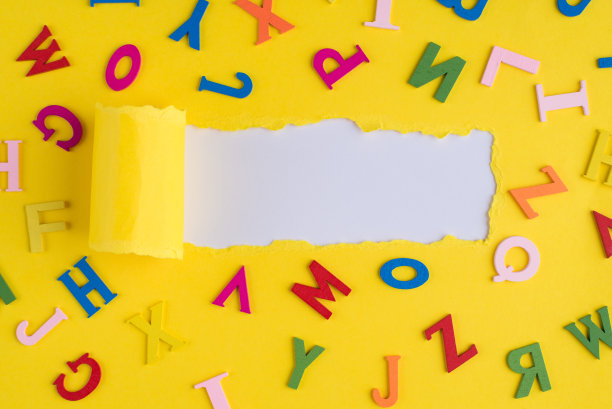 上面的头顶上的照片彩色字母和撕亮黄色纸在白色背景与copyspace图片下载