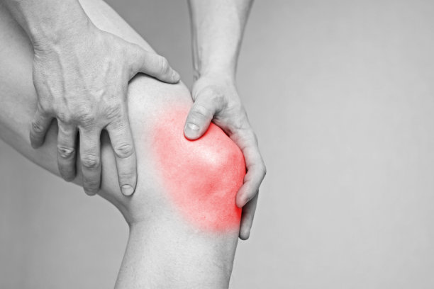 男人膝盖疼。卫生保健的概念。膝盖疼痛的人。黑白照片与红点图片下载